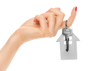 Hand holds key with a keychain the shape of house.