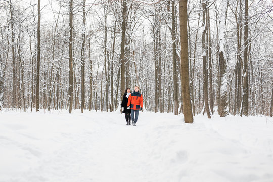 Young couple in love walking in the snowy forest