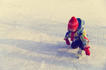 Fototapeta na wymiar cute happy little girl learn to skate in winter
