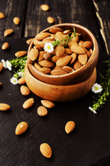 raw almonds in a wooden bowl selective focus
