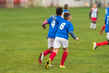 Obraz premium Young soccer boys hugging during football match