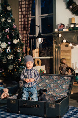 little boy in a suitcase in the Christmas decor, the child in the new year