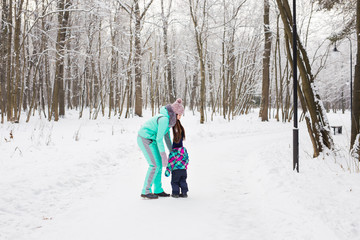 Happy family. Mother and child girl on a winter walk in nature.