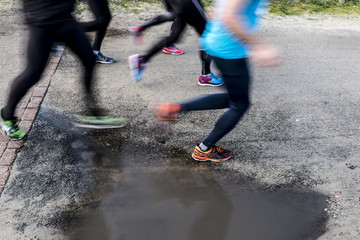 Runners marathon running next to puddle