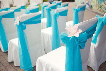 Fototapeta na wymiar Beautiful wedding chairs with lily decoration on the ceremony