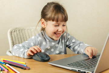 Девочка нажимает клавишу пробела на компьютере и смеется
