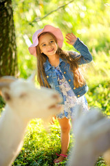 girl feeds goats