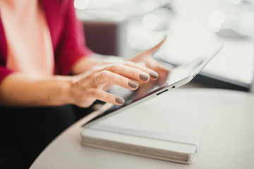 Tablet PC close up photo with woman hands macro shot. Girl using tablet in the cafe.