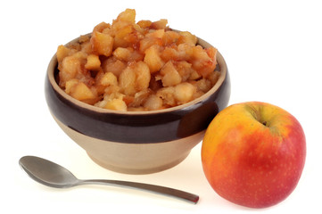 Bol de pommes caramélisées avec une pomme ) côté sur fond blanc