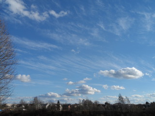 beautiful autumn landscape: blue sky with white wavy clouds over the city