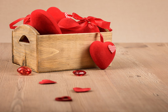 Valentine's day decoration /
Red hearts in a wooden box on a wooden background