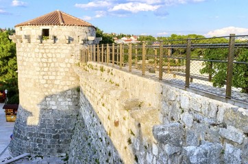 The round venetian tower of Frankopan Castle, at Kamplin square in Krk, Croatia - Frankopanski Kastel and plate with a winged Venetian lion, the symbol of St. Mark. Part of the medieval city walls.