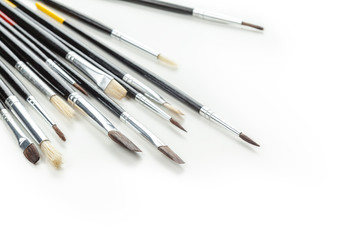 close up of paint brushes on white background
