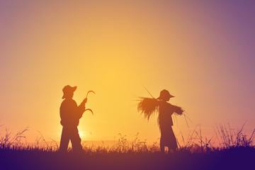 Naklejka na ściany i meble Silhouette of children holding rice on field in harvest season,Happy farmer at sky sunrise in the morning