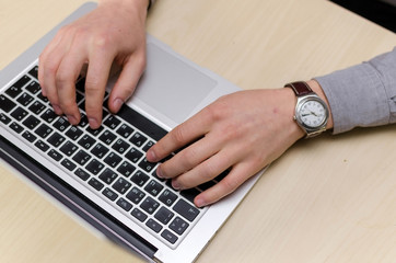 Close-up photo of man typing on laptop