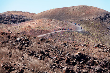 Nea Kameni volcanic island in Santorini, Greece. Group of people