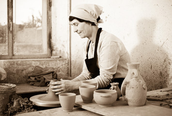 Female elderly master among the pottery