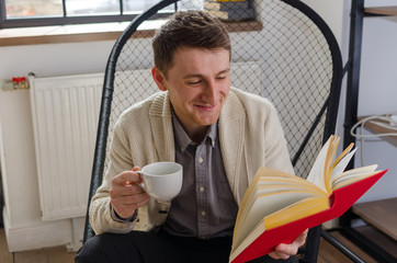 Man reading a book and drinking coffee