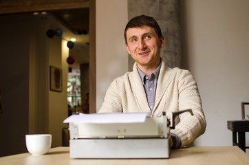 Fototapeta premium Young man is working on the typewriter