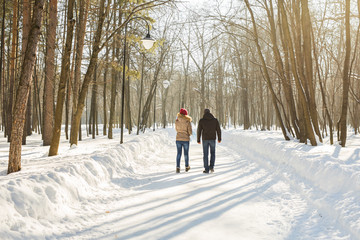 parenthood, fashion, season and people concept - happy family with child in winter clothes walking outdoors.