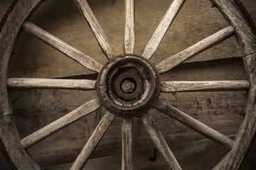 Old wooden wheel on a wooden wall