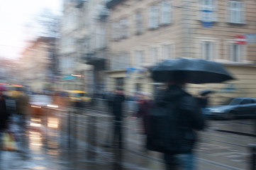 people walking in the street on a rainy day motion blurred