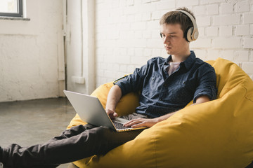 Young man in headphones using laptop