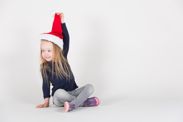 kleines Mädchen spielt mit Weihnachtsmütze