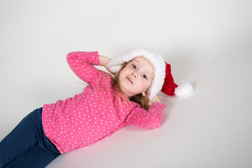 kleines Mädchen spielt mit Weihnachtsmütze