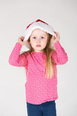 kleines Mädchen spielt mit Weihnachtsmütze