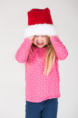 kleines Mädchen spielt mit Weihnachtsmütze