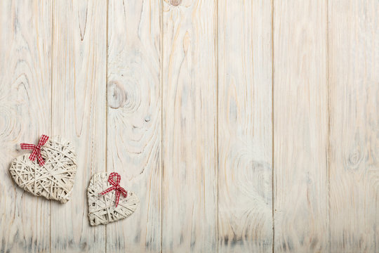 Concept Of Valentine's Day. Wicker hearts on wooden background w