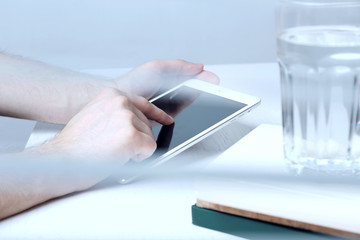 Fototapeta premium Man holding tablet in hands. View through blinds