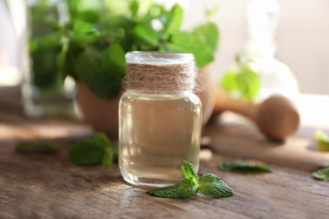 Essential oil with mint on wooden table
