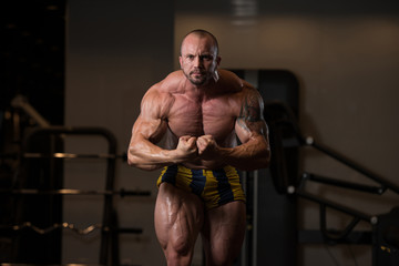 Fototapeta na wymiar Bodybuilder Man Posing In The Gym
