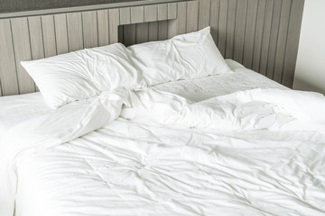 rumpled bed with white messy pillow decoration in bedroom