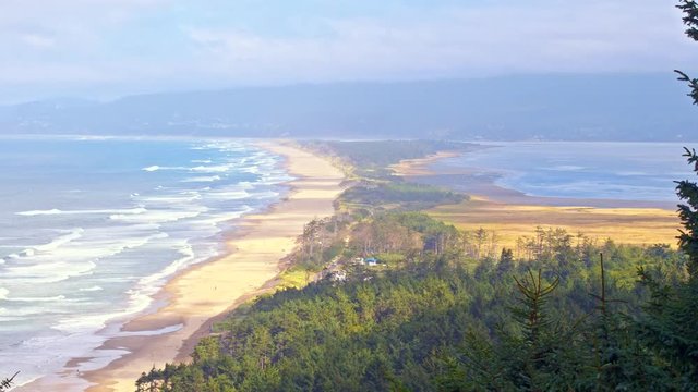 Cinematic, sliding shot of iconic Ocean shore in Oregon by Pacific Coast Highway, scenic landscape. Spectacular coastal vista views of distant breaking waves, misty forests, sea mounts and mountains