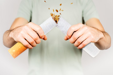 Quit smoking - male smoker breaking giant cigarette