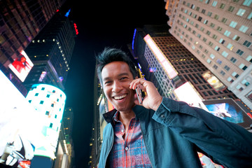 Portrait of man talking on phone at Times Square - obrazy, fototapety, plakaty