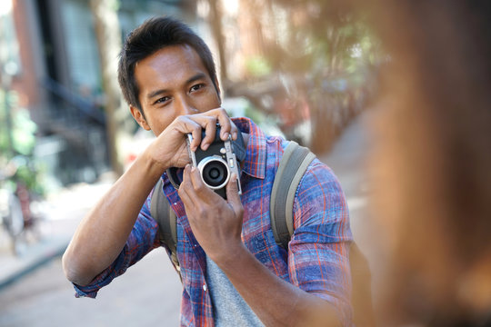 Young man taking picture of model in the street