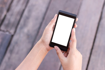 Young woman's hands holding smartphone with blank screen on old