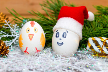 Santa Claus and a cock at Christmas and New year. Unusual eggs from the face of the muzzle.A Christmas cartoon.