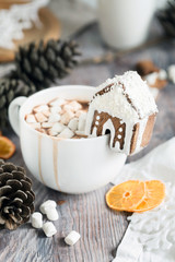 Big mug of hot cocoa with marshmallow decorated with mini ginger