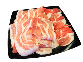 Isolated sliced pork on black dish.