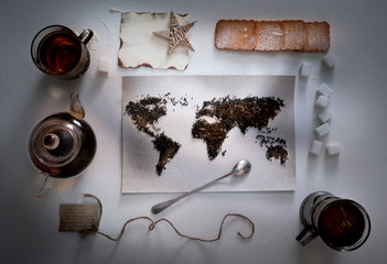map of the world, lined with tea leaves. Eurasia, America, Australia, Africa. vintage. sugar, note, cracker, spoon . top view. flat lay