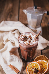 Cocoa or latte or hot chocolate with marshmallow and flavored with cinnamon. On a brown wooden background. Christmas present. Christmas concept. Christmas holiday.