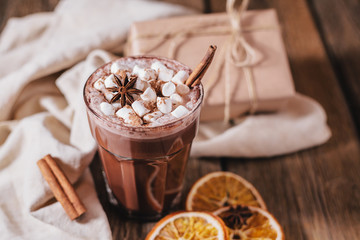 Cocoa or latte or hot chocolate with marshmallow and flavored with cinnamon. On a brown wooden background. Christmas present. Christmas concept. Christmas holiday.