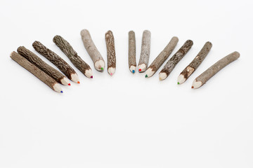 Color wooden pencils is on the light background. Unusual pencils for drawing made how logs.