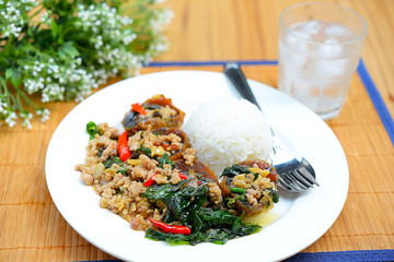 Rice topped with stir-fried preserved egg slice and basil.
