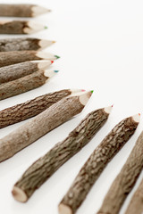 Color wooden pencils is on the light background. Unusual pencils for drawing made how logs.